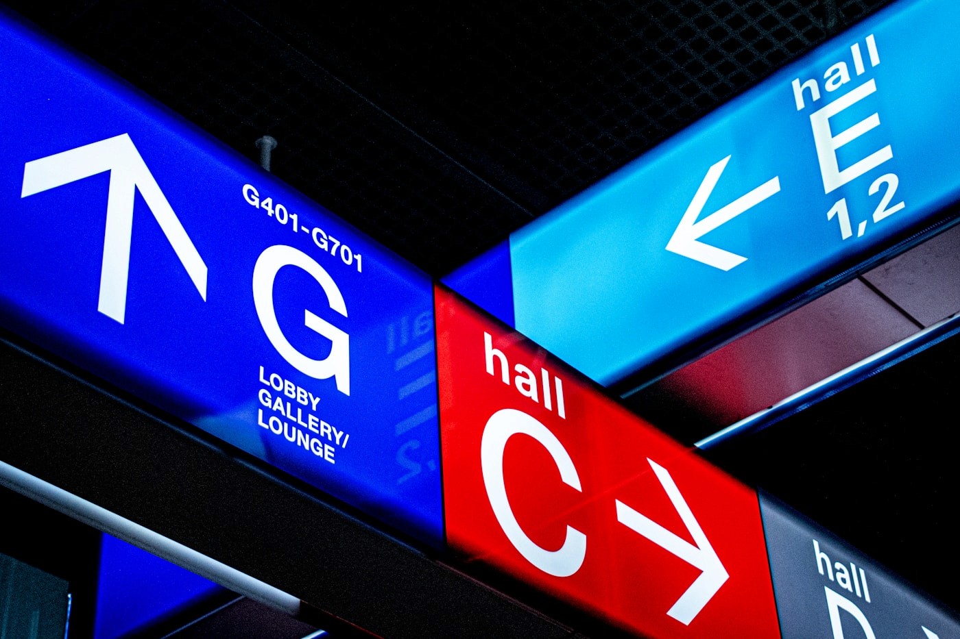 Large-format digital directional signs guiding visitors between venue halls