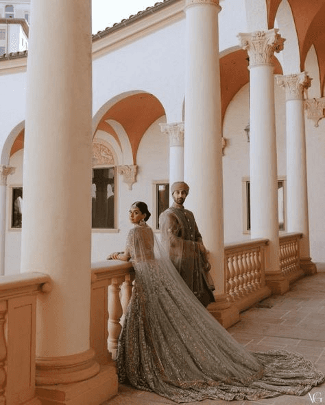 Refined portrait of a wedding couple in a European-inspired courtyard, highlighting opulent fashion and sophisticated editorial wedding photography style.