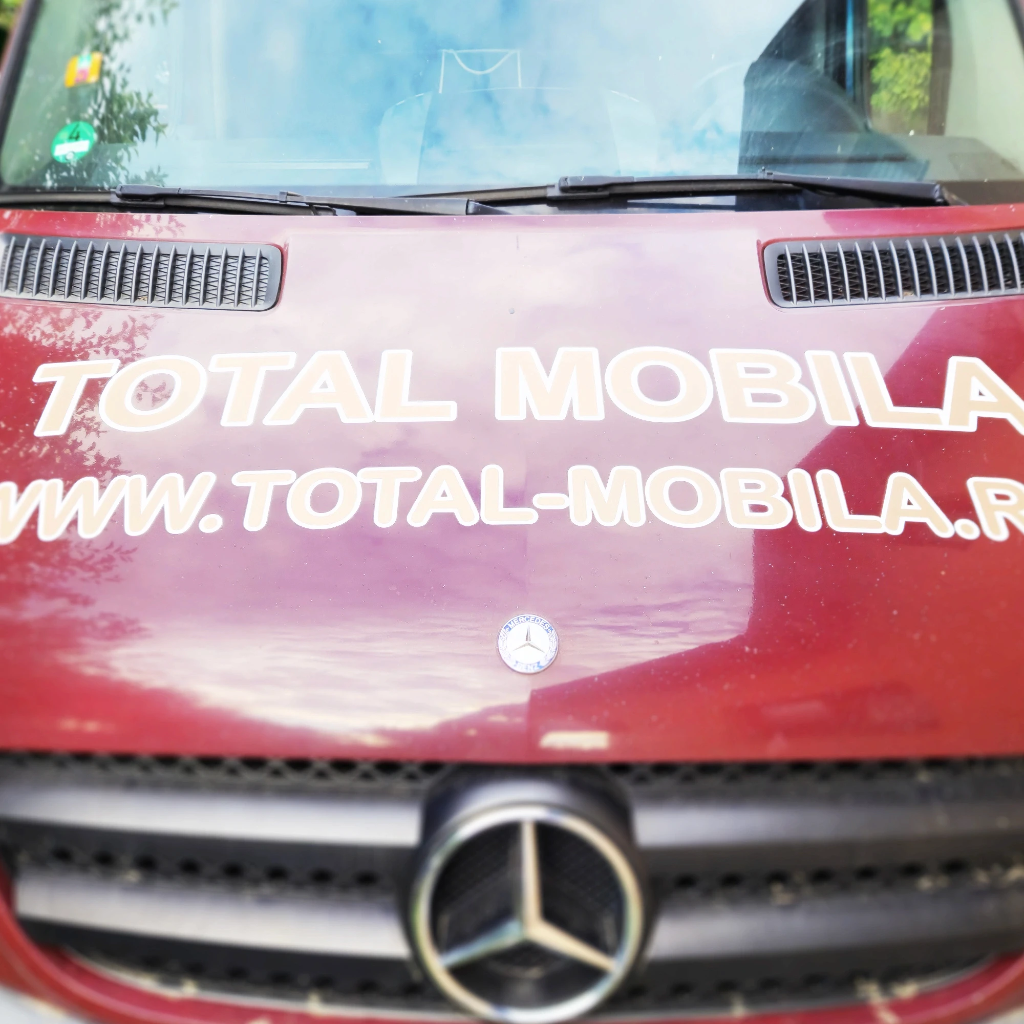 Vedere frontală dubă Total Mobilă colantată, logo pe capotă