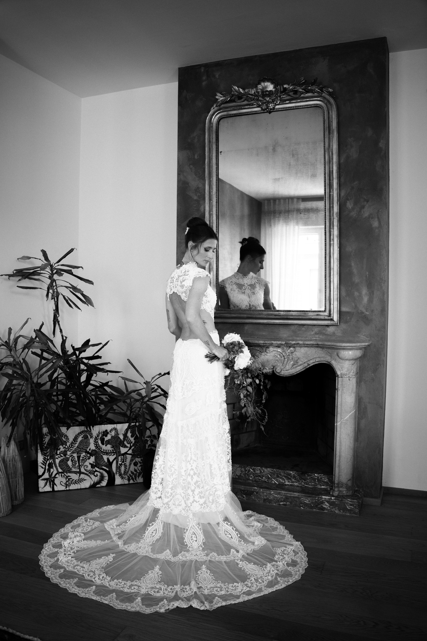 Sposa in pizzo davanti allo specchio antico della Rocca di Soragna, riflesso nuziale in bianco e nero