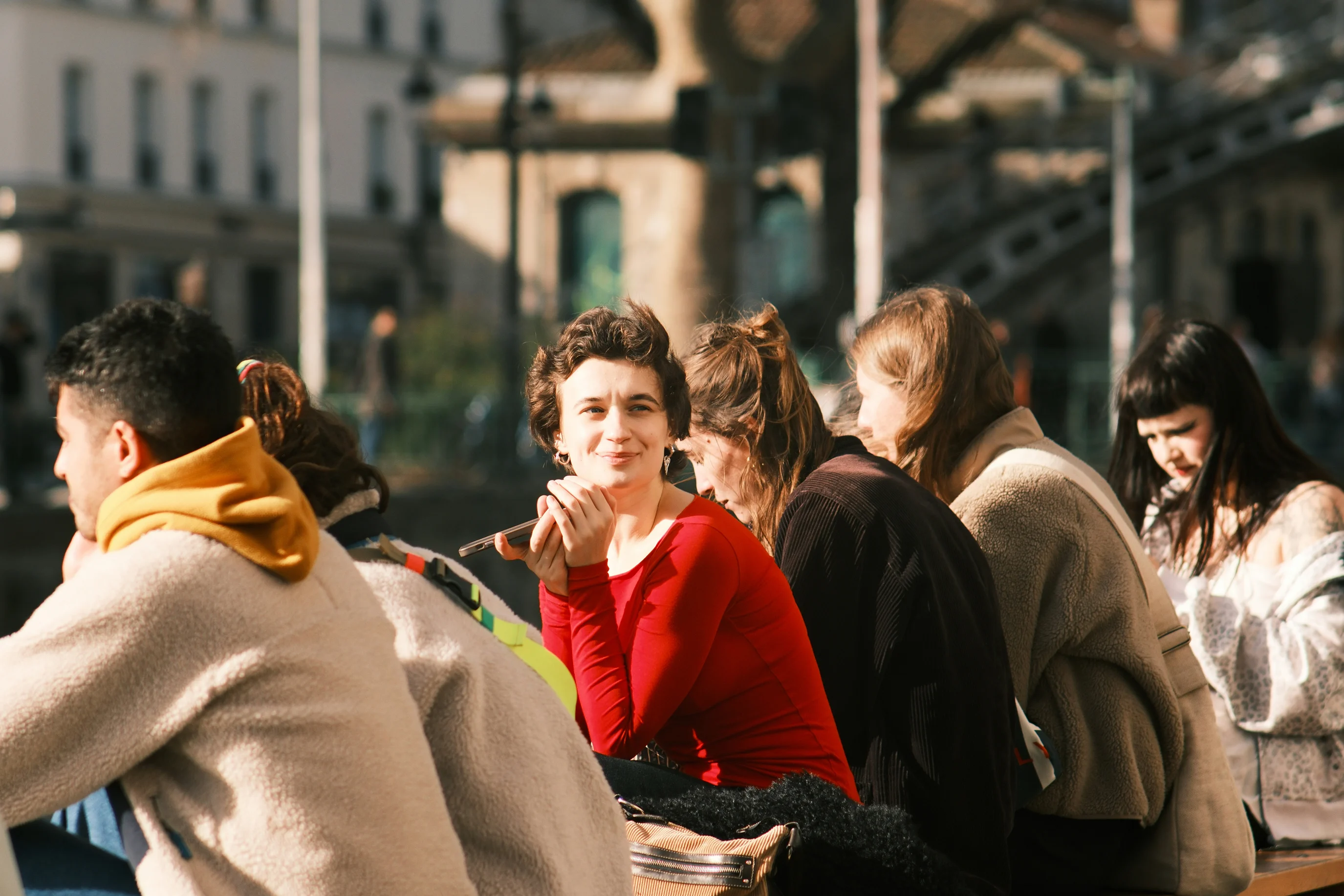 People chatting around a table in a busy cafe.