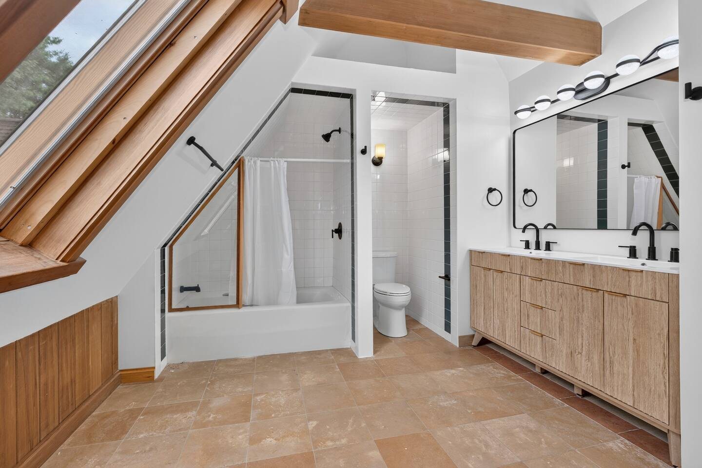 Bathroom under the A-frame with a double vanity and tub-shower