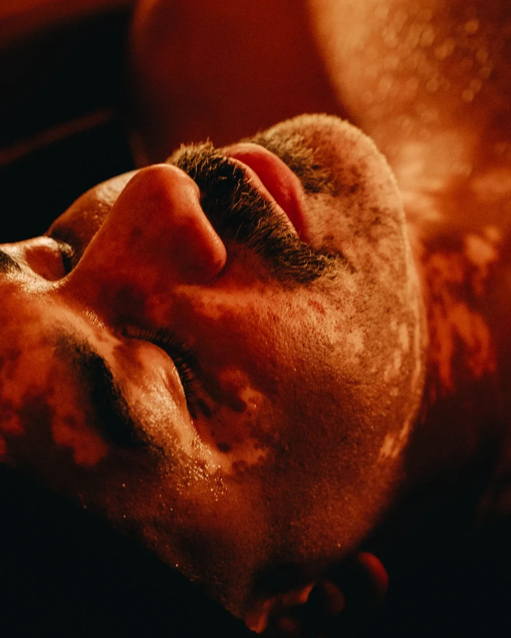 Close-up of a guest resting with eyes closed during a meditative relaxation ritual at AetherHaus, Vancouver.