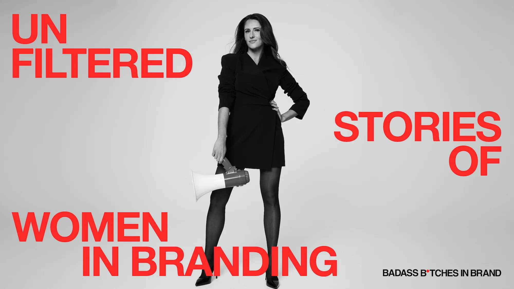 A black and white studio photograph of Stacey Saunders standing confidently in a black blazer dress and heels, holding a megaphone at her side. Bold red typography surrounds her reading "Unfiltered Stories of Women in Branding." The Badass B*tches in Brand logo sits in the bottom right corner.