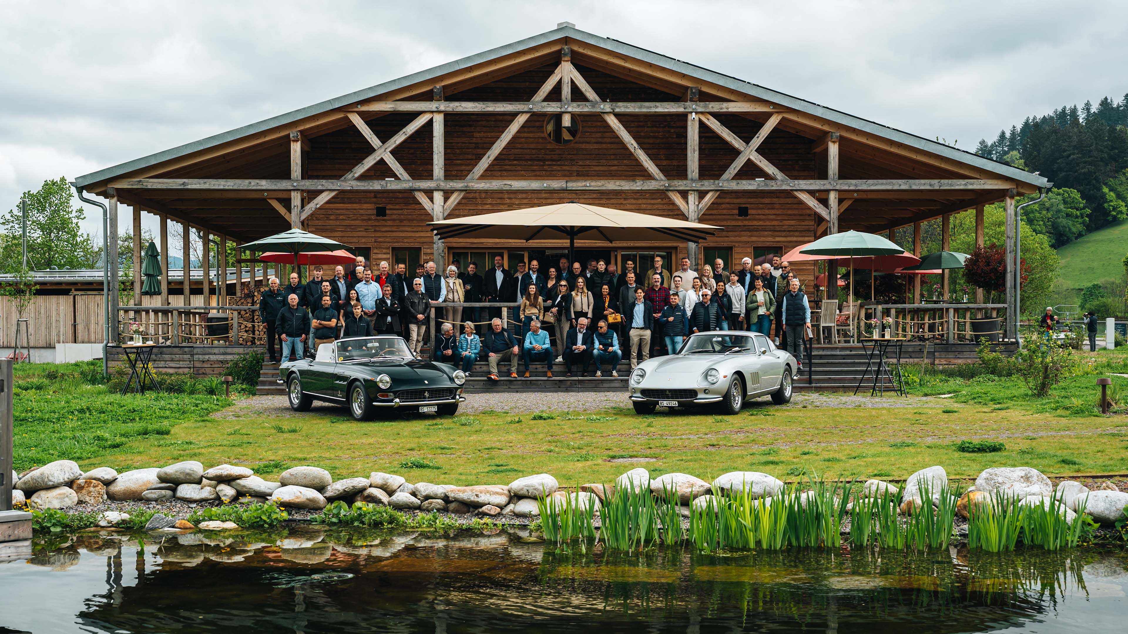 Fotografia di gruppo di persone dietro a due Ferrari d'epoca