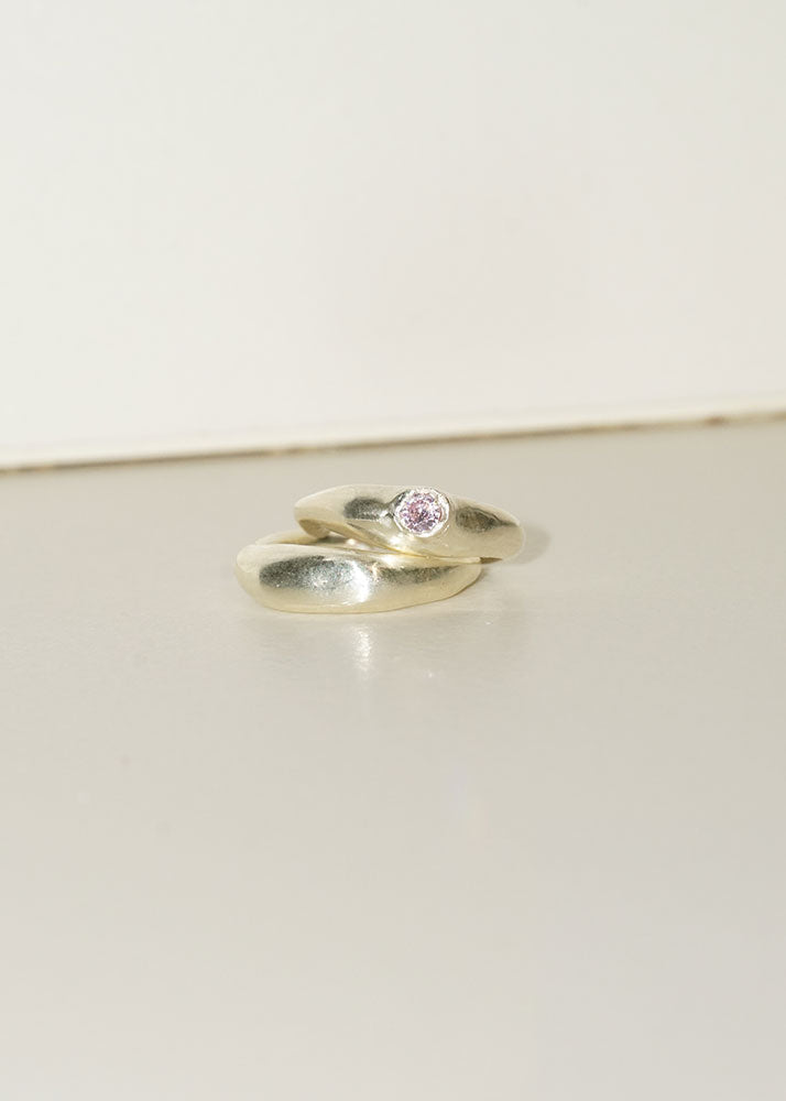 Silver ring with a pink gemstone on a light gray background