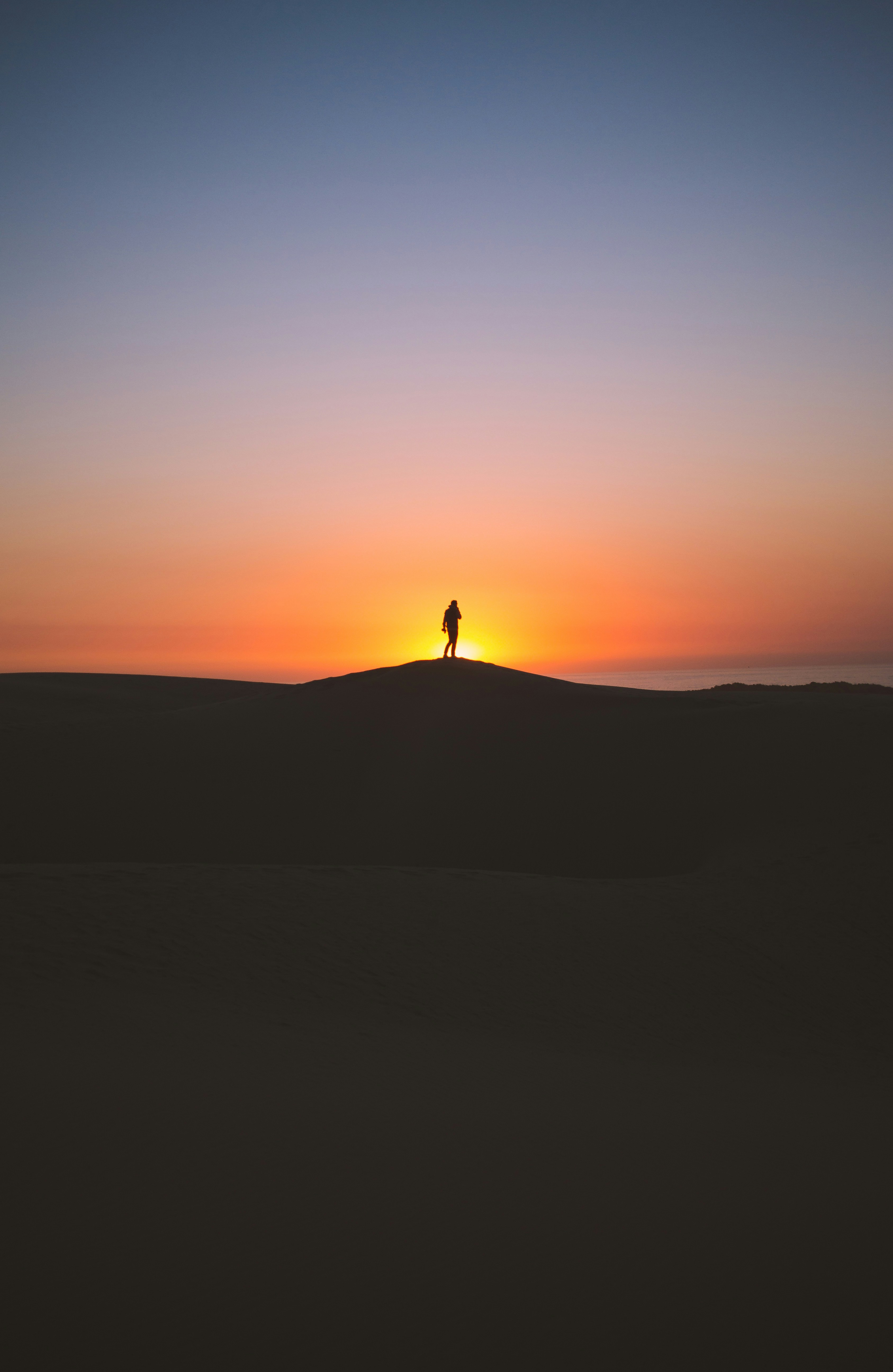 silhouette of person standing on hill