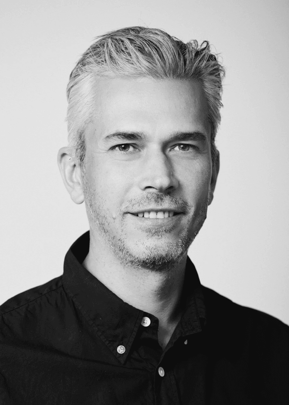 Portrait of a man with blue eyes and a beard, wearing a denim shirt