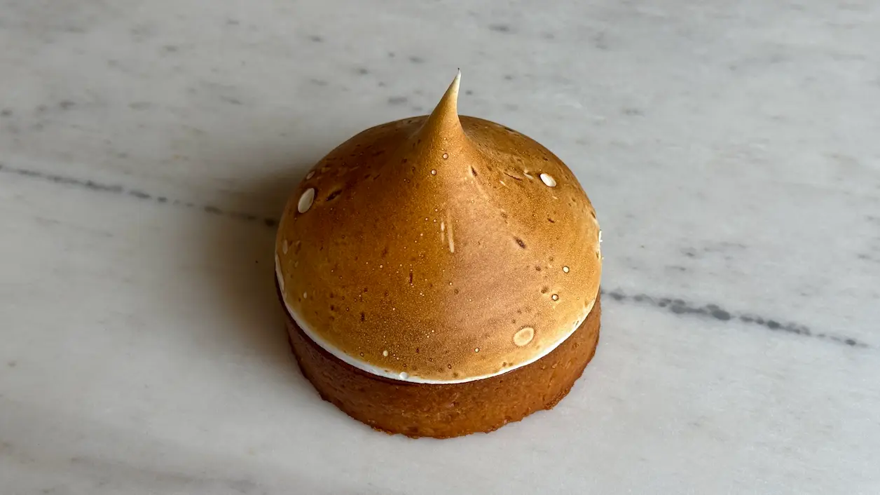 Caramel meringue dome dessert with sesame seeds on biscuit base