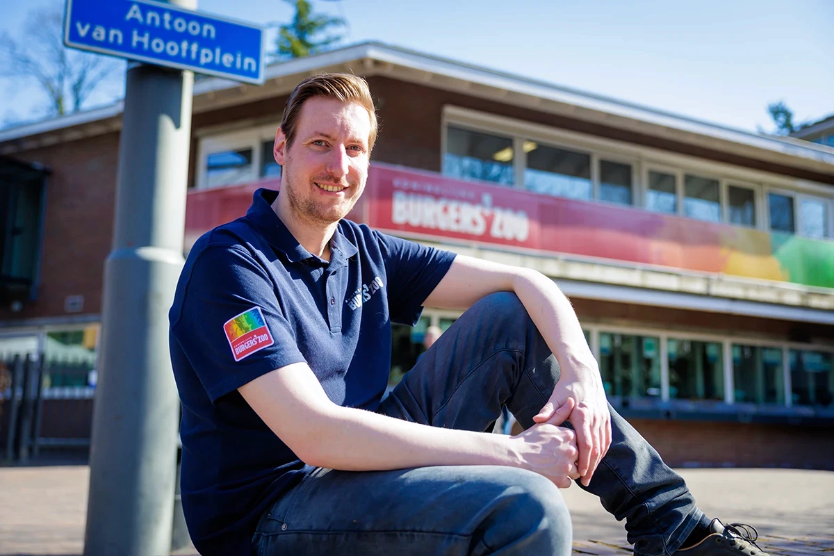 Medewerker van Burgers' Zoo voor de ingang van de dierentuin