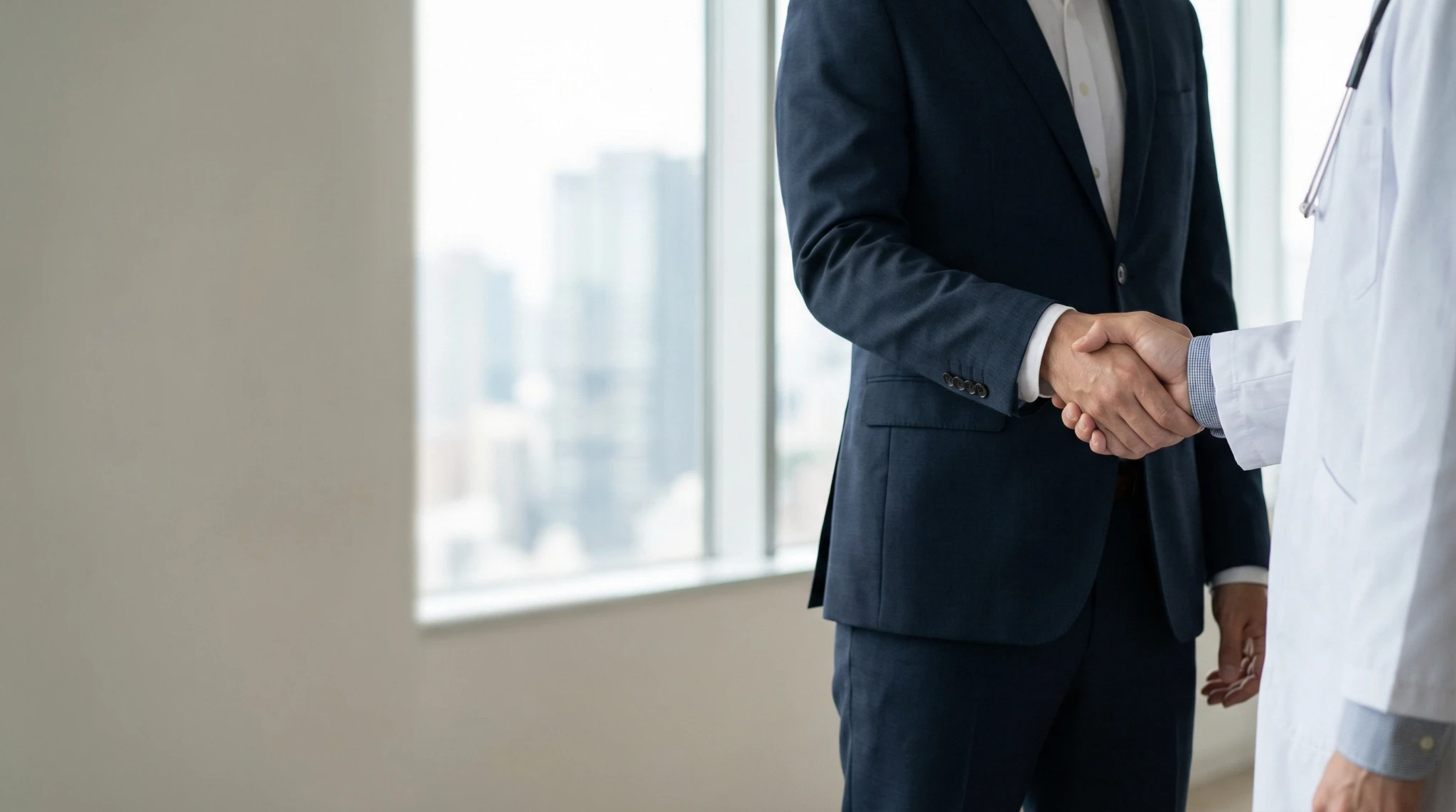 Woman looking at a computer screen in warm natural light, focused and thoughtful, with sunlight casting soft shadows on the wall behind her.
