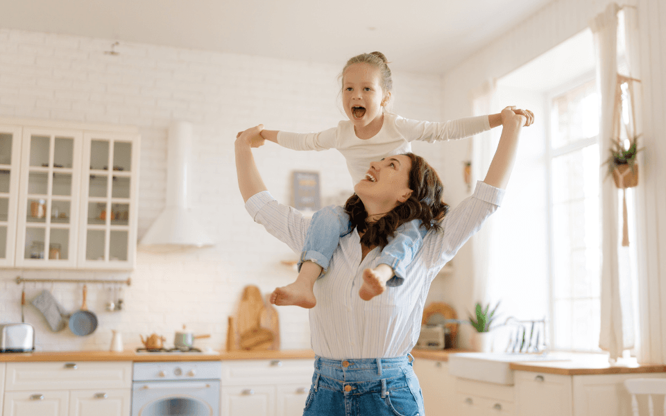Woman with daughter on shoulders, showing flexibility and being relaxed. 