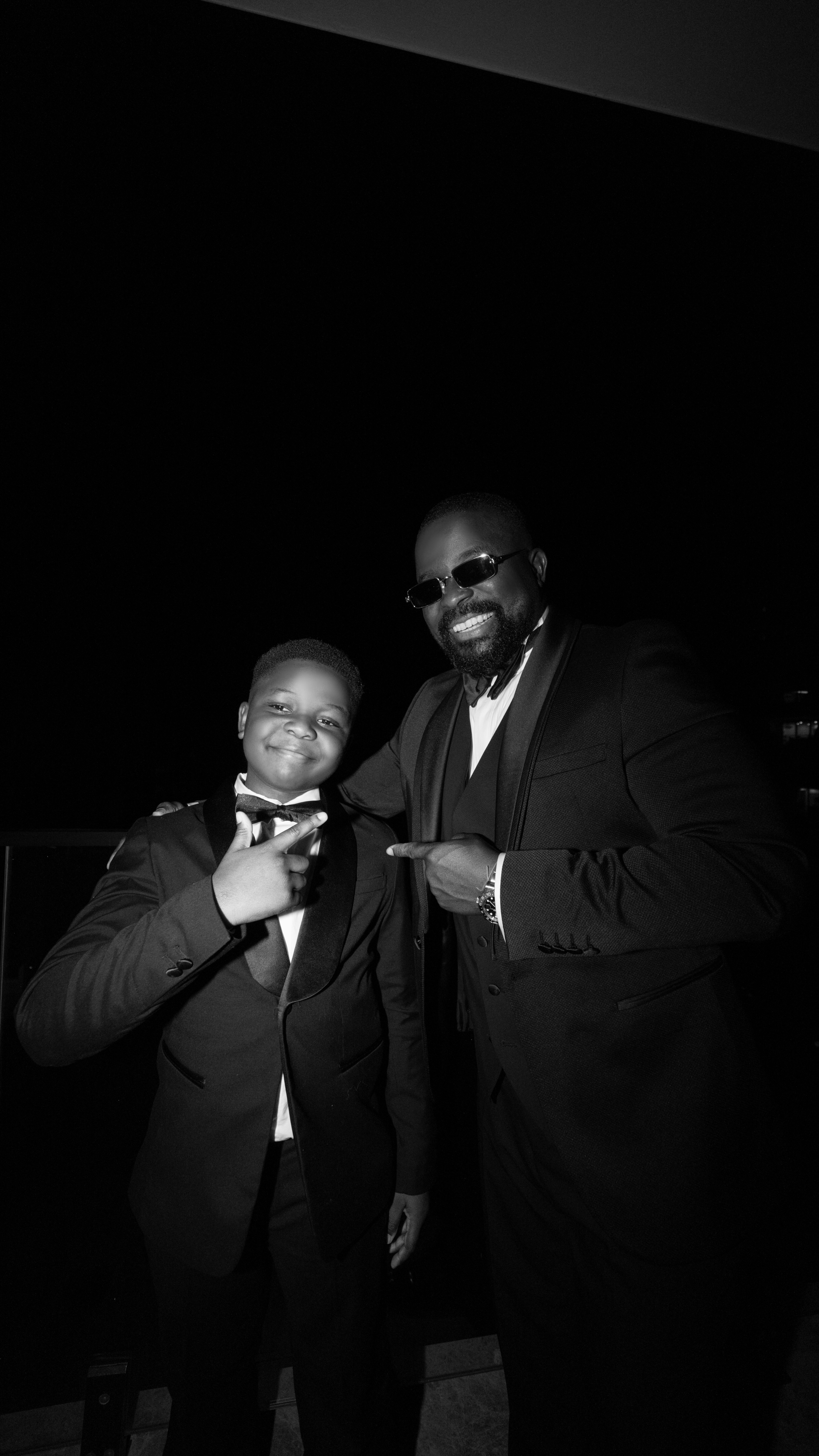 Two men in suits posing for a picture.