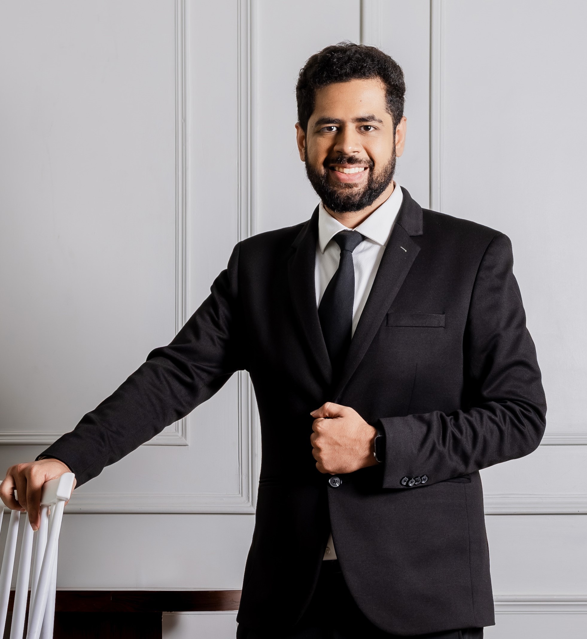 man in black suit jacket holding brown leather bag