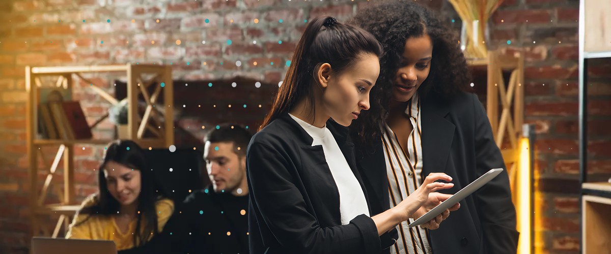 colleagues looking at notes on a tablet