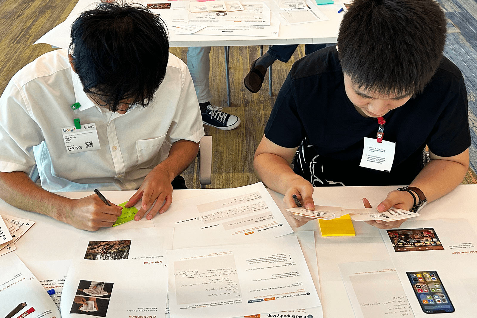 The front view of two workshop participants using ideation cards to generate ideas during an ideation session