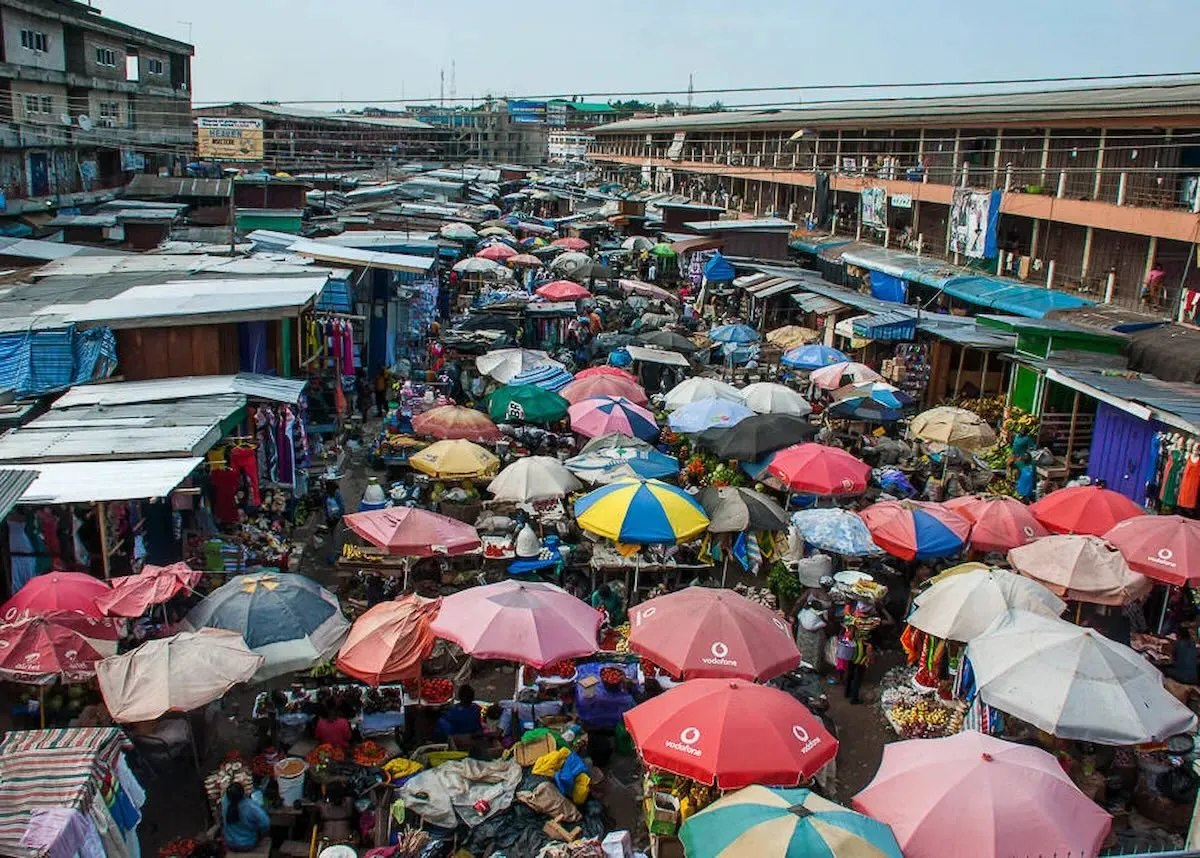Kejetia Market filled with vibrant stalls and umbrellas in Kumasi.