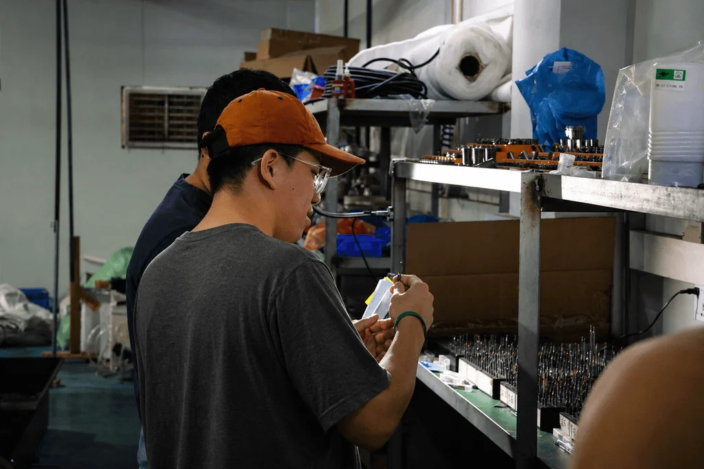 Inspector checking a product and recording observations on the factory floor