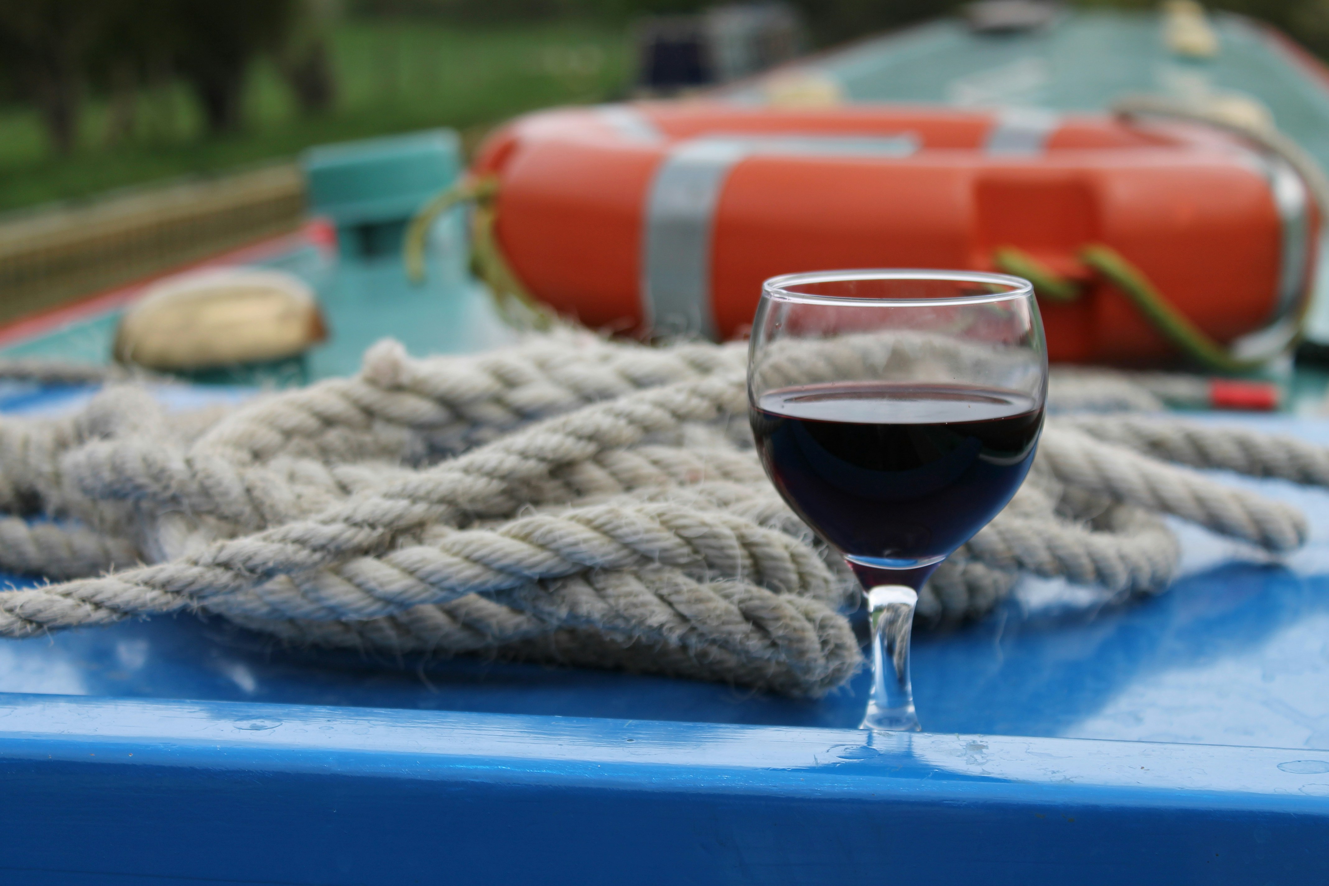 a glass of wine sitting on top of a blue table