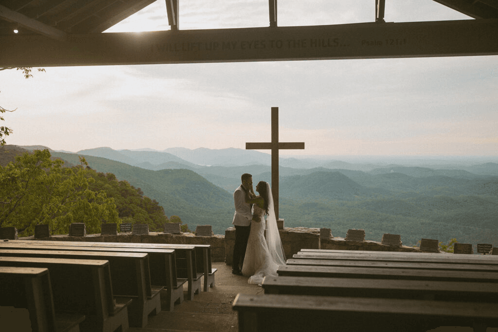 Photo of a cross and a wedding couple overlooking land for miles
