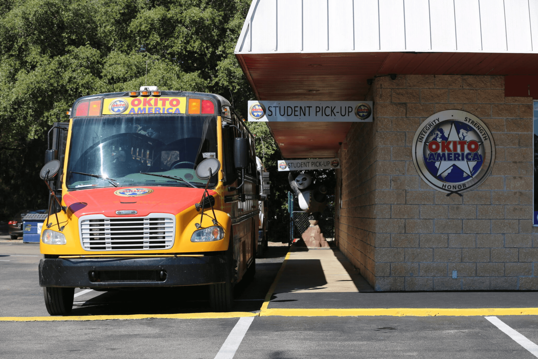 A pickup bus parked next to an Okito building. 