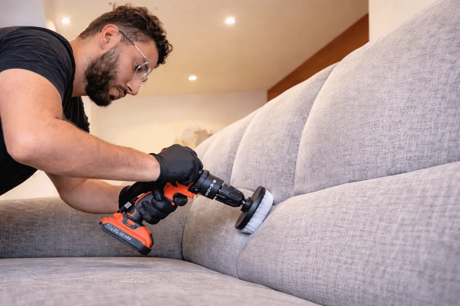 Nassim de chez Krystal Hygiène qui nettoie un canapé