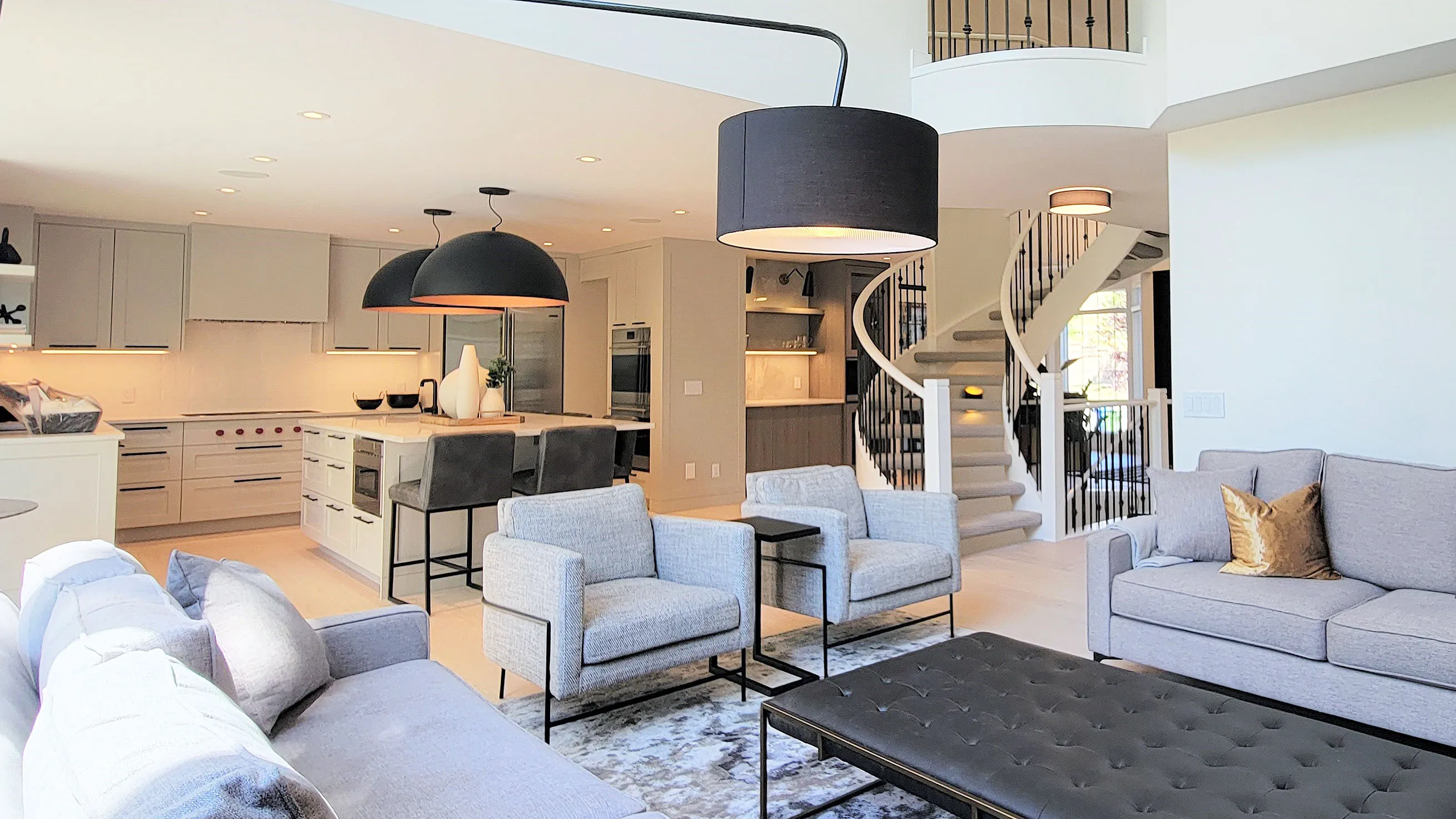Image of large open kitchen with light grey millwork and black accents.