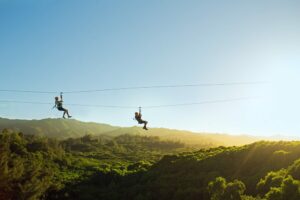 Two people enjoying an Oahu zipline tour.