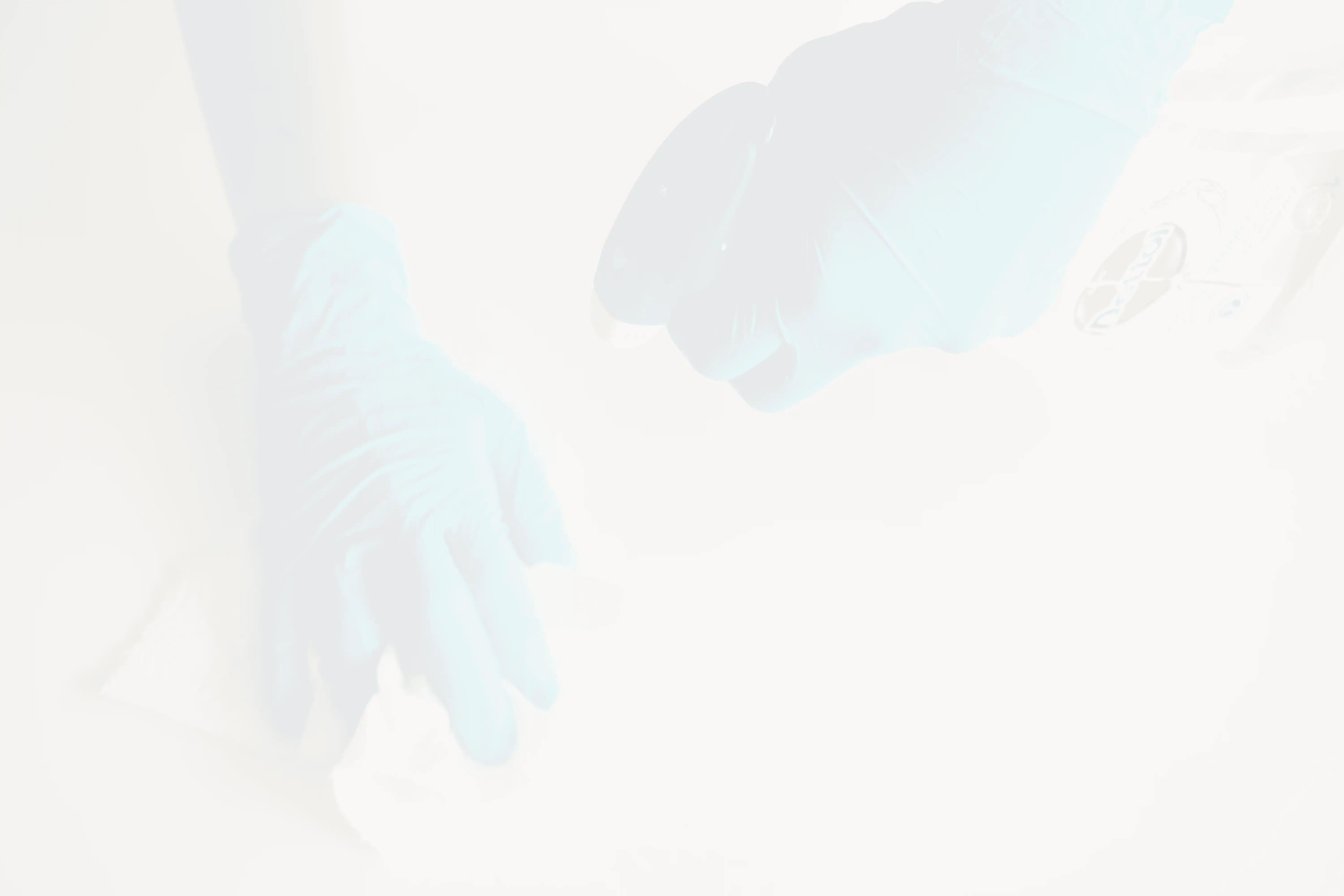 person in blue gloves holding white textile