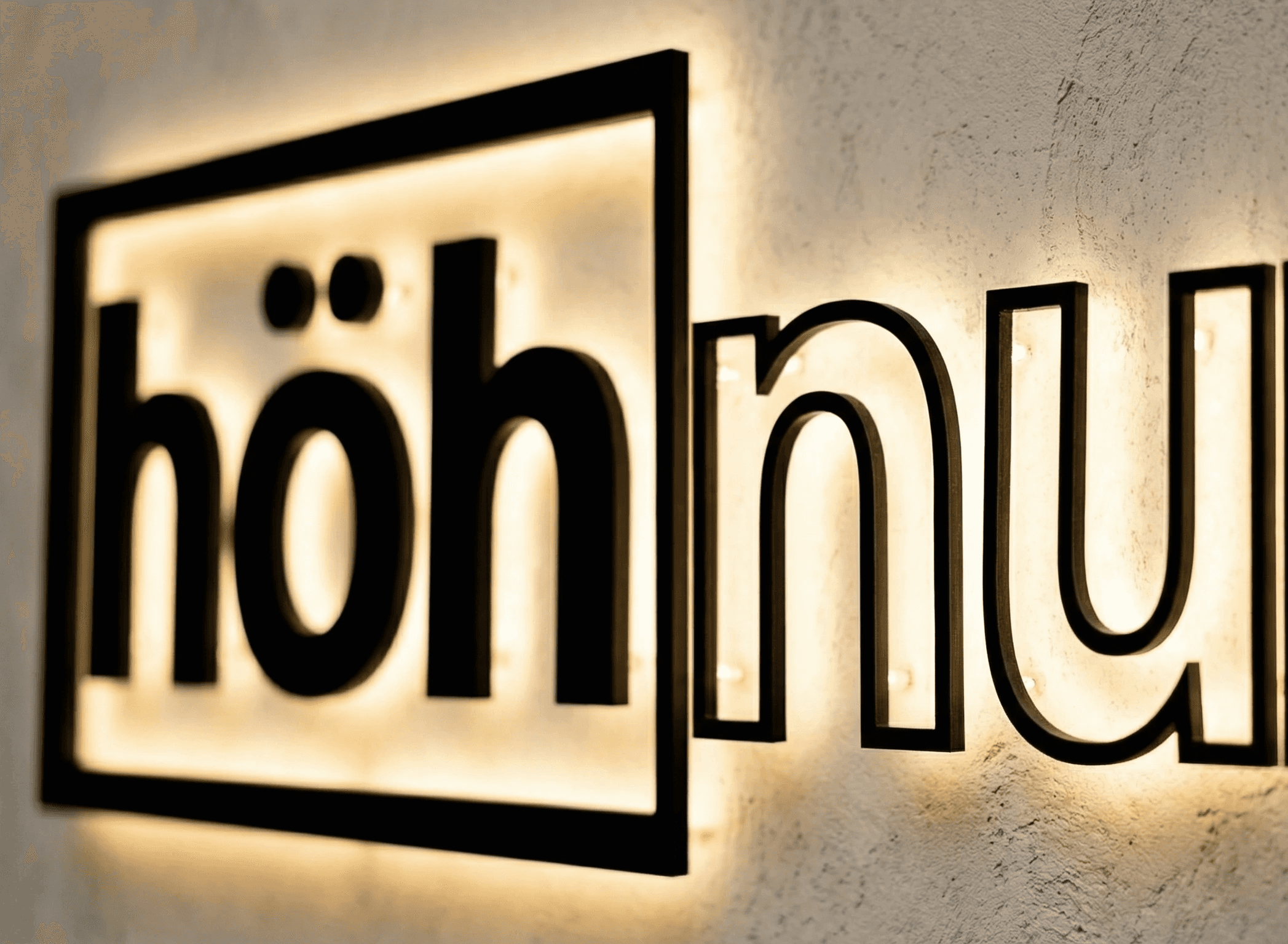 Young person with short, tousled blonde hair wearing an oversized, vibrant orange turtleneck sweater against a soft grey background, conveying a cool, modern look.