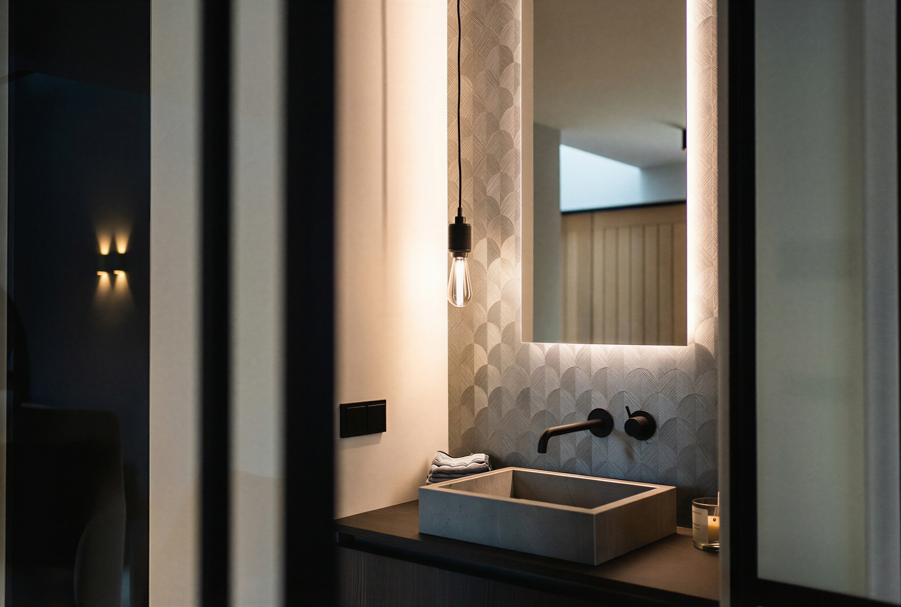 Verfijnde materiaalcombinatie in de badkamer met geometrisch wandbehang, een betonnen waskom en minimalistische zwarte armaturen.
