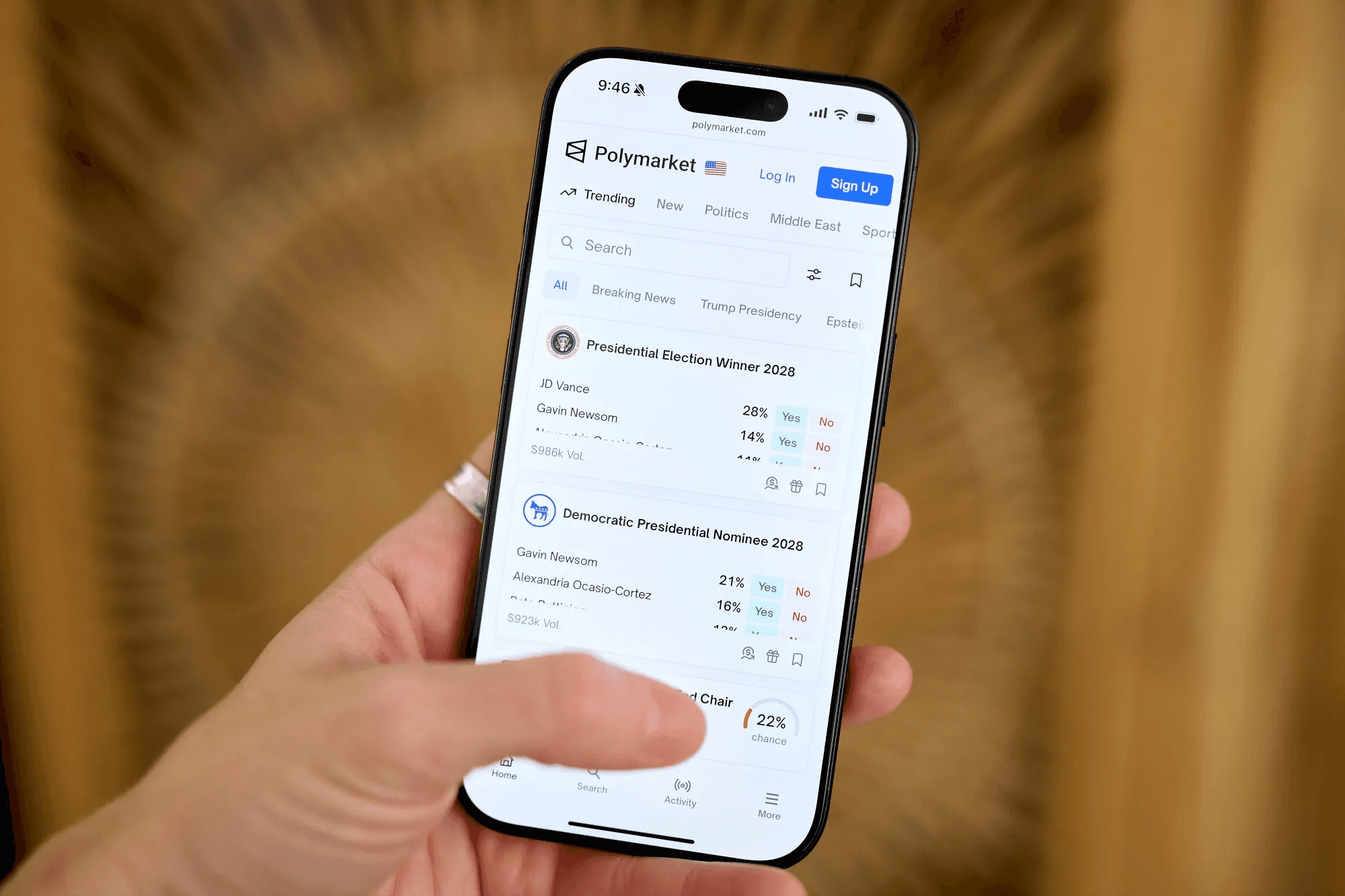Person holding phone showing Polymarket - Where Is Polymarket Based