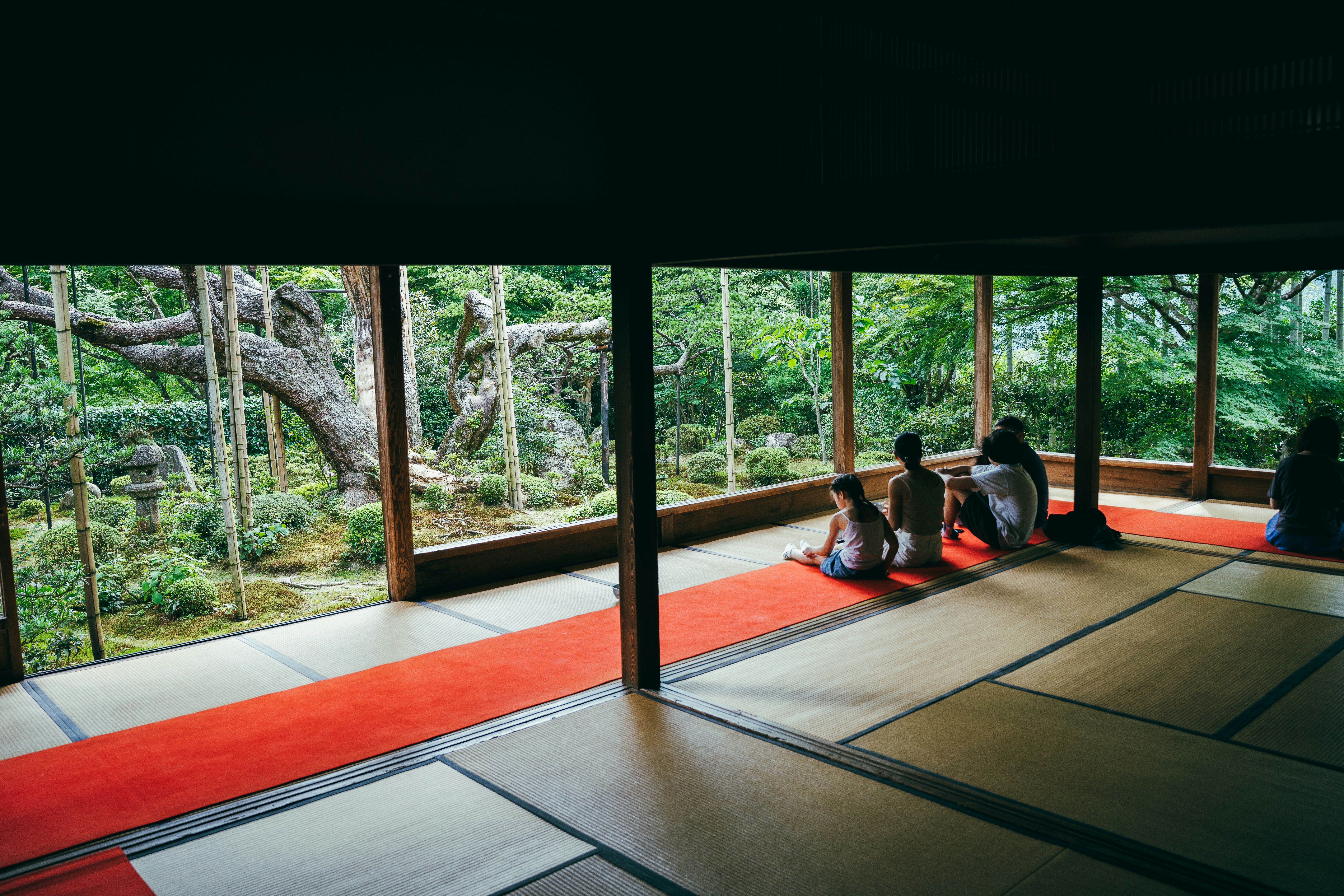 People sitting in a traditional japanese room overlooking garden