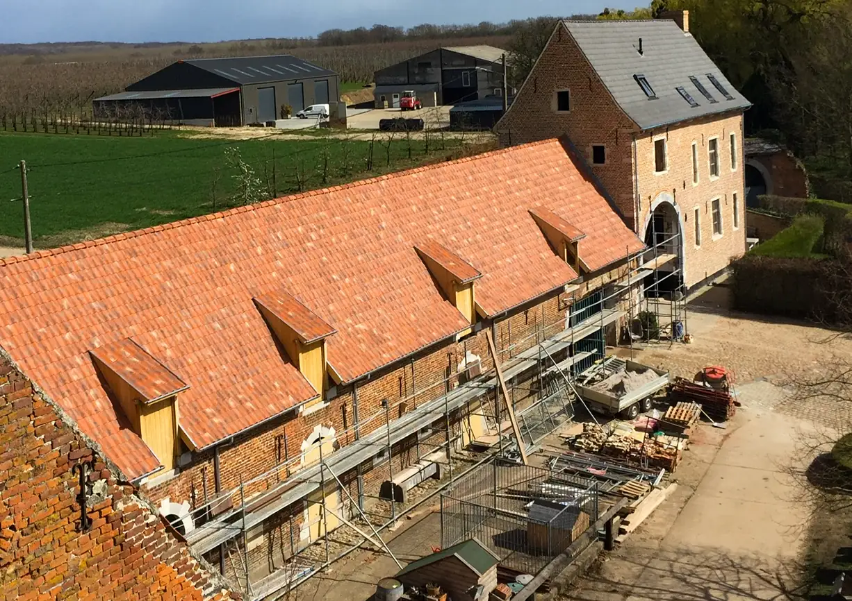 A big wooden roof structure being filled with rooftiles.