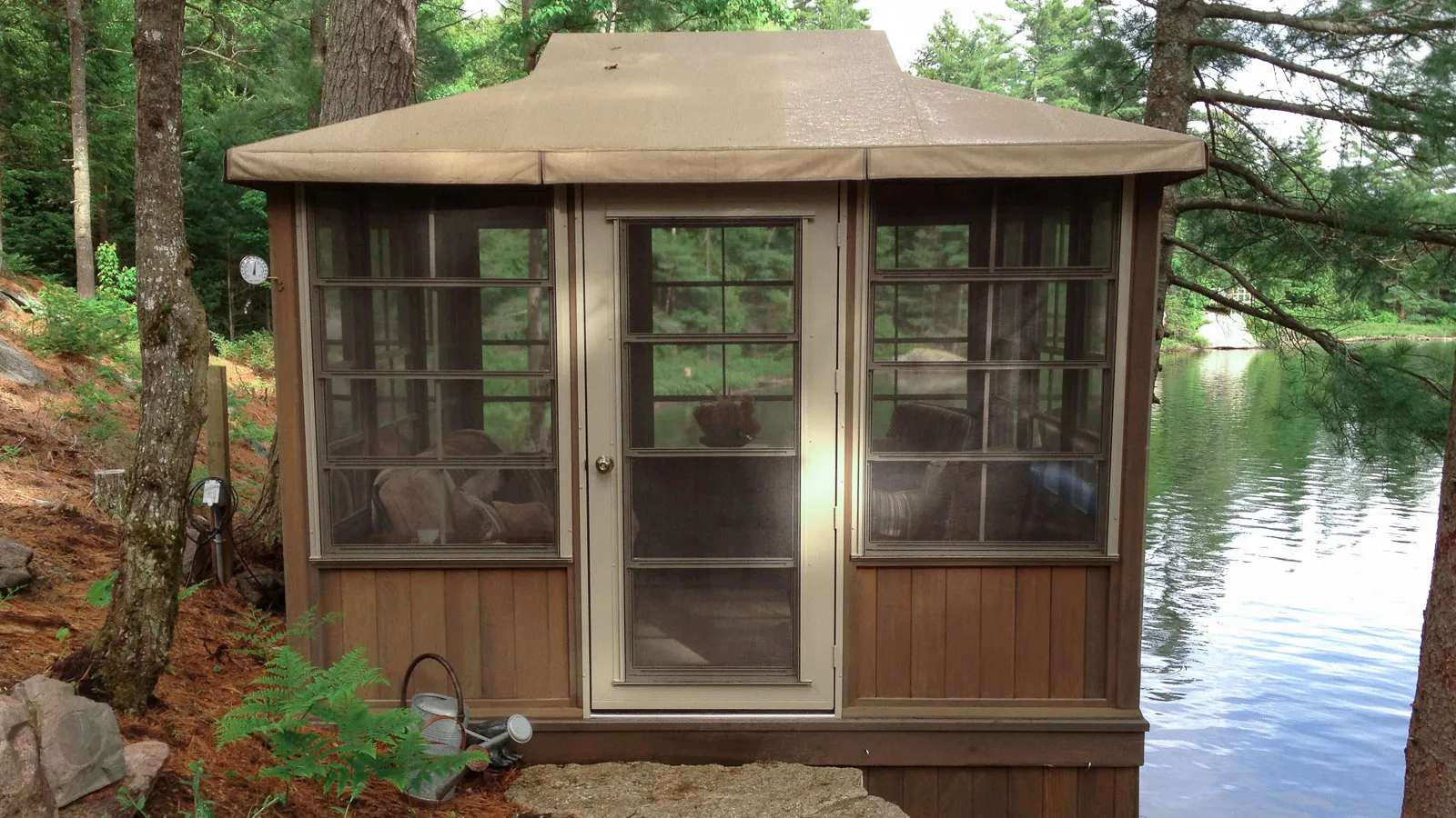 Screened in gazebo on the shoreline of lipsy lake beside split limestone steps.
