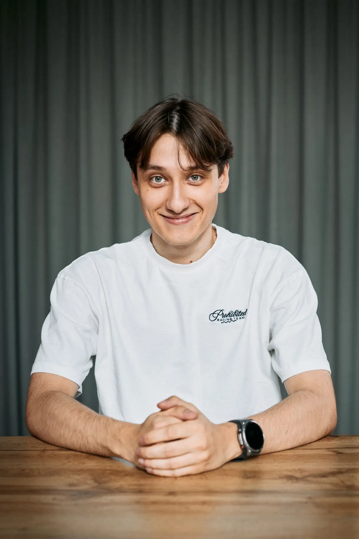 Portrait of a laughing person with curly hair wearing a white shirt
