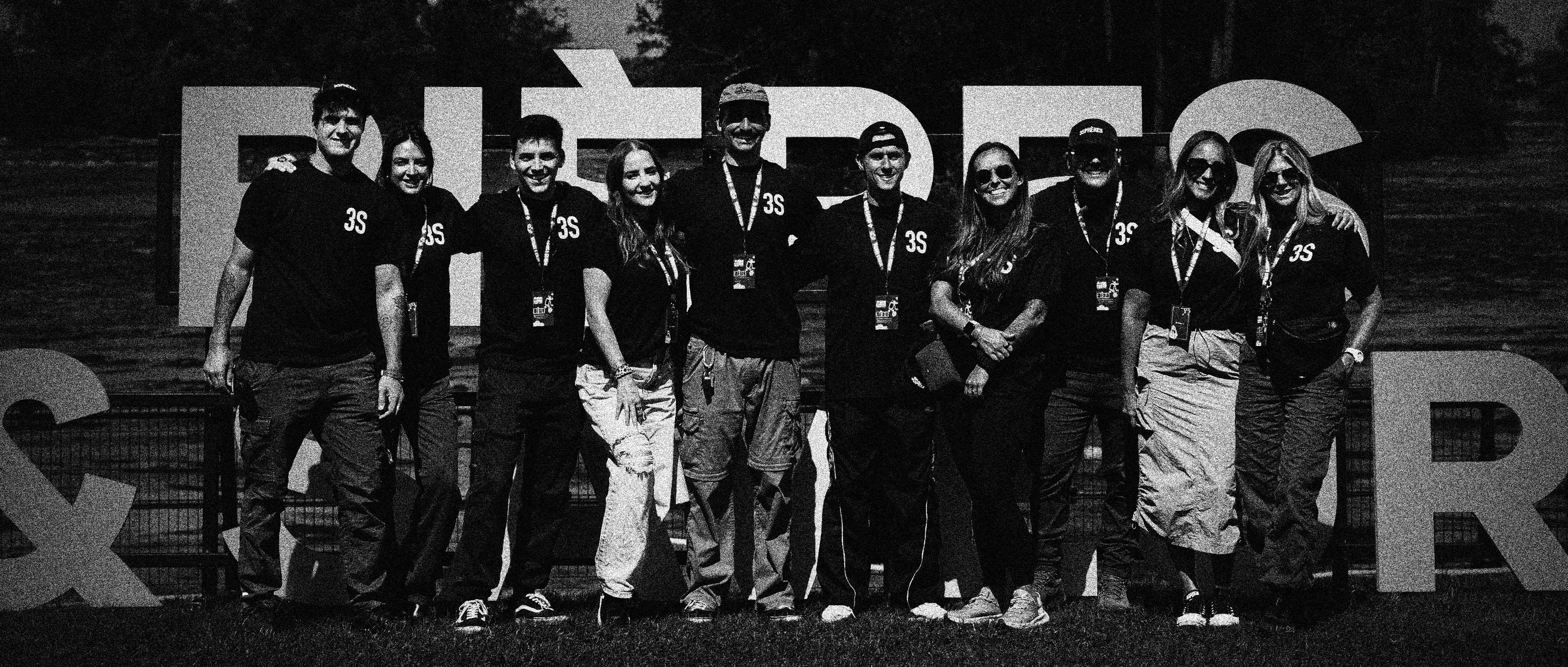  Collaborative work session overhead view of six people collaborating at a rustic wooden table with coffee, papers, and a laptop