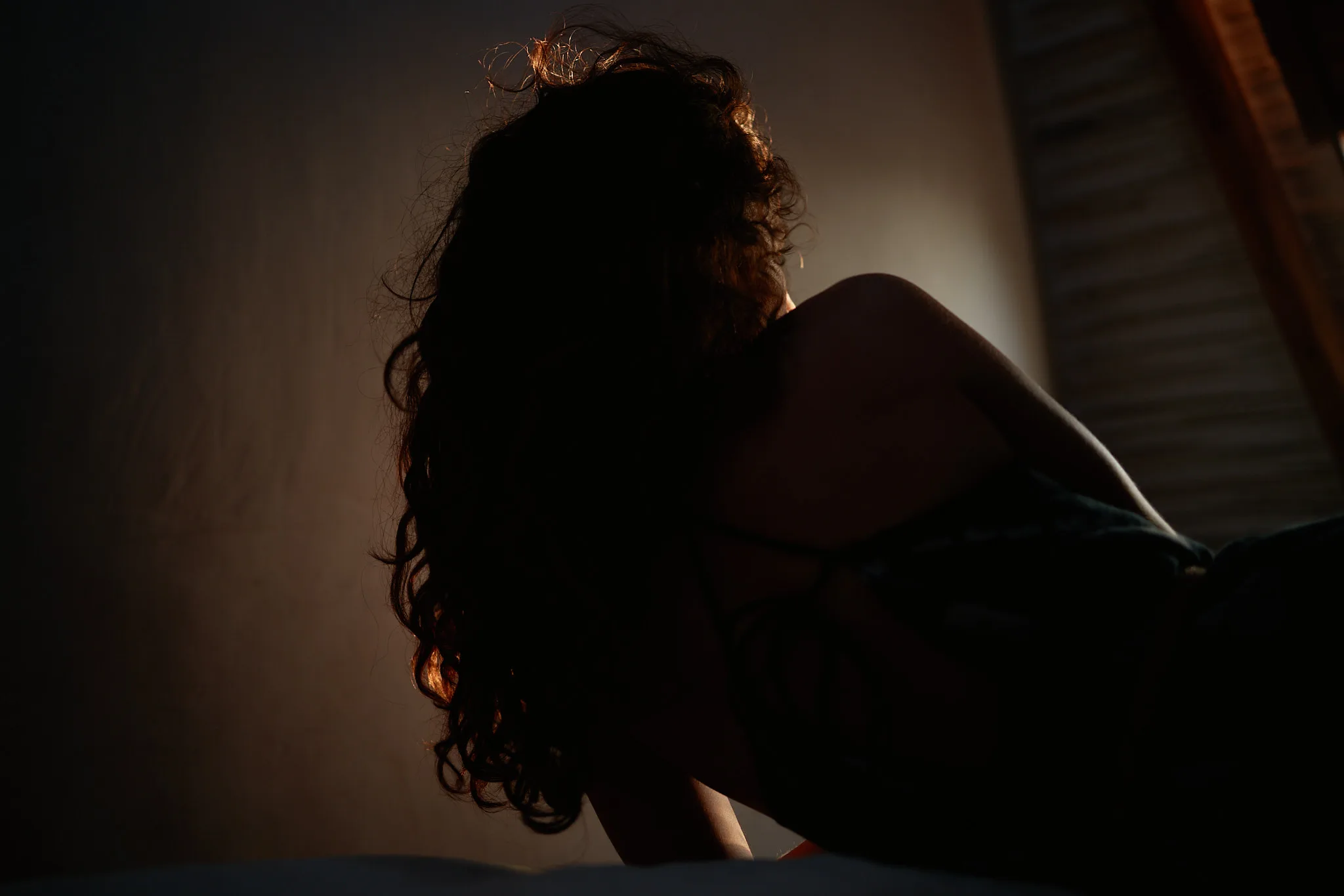 curly hair silhouette against window light — portrait photography by Tom Kubik