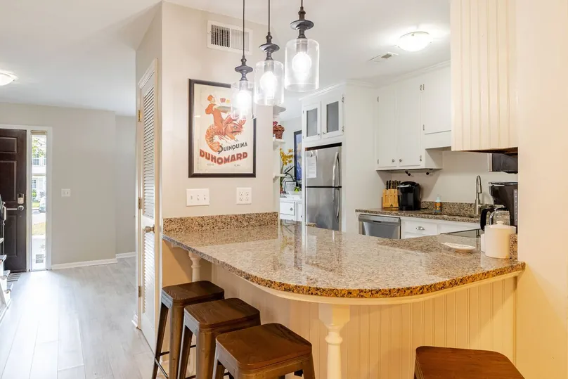 Granite breakfast bar with three stools and a vintage poster