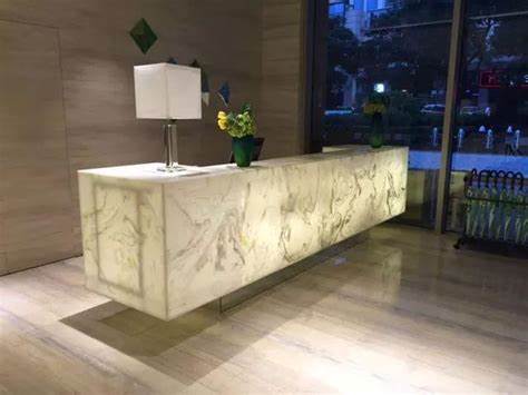 A floating reception desk made of illuminated marble, giving a modern and clean aesthetic to the entrance area.