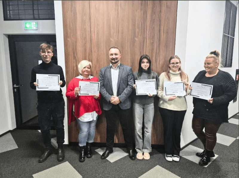 Flaga Unii Europejskiej z dwunastoma żółtymi gwiazdami na niebieskim tle, powiewająca na wietrze na tle częściowo zachmurzonego nieba.