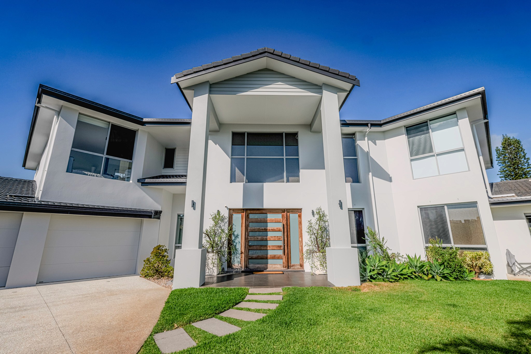 Freshly repainted Gold Coast house exterior against a blue sky — Red Dragon Painting