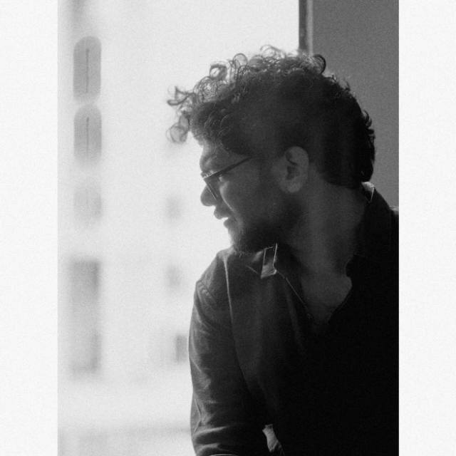 Black and white portrait of a man with a beard and glasses