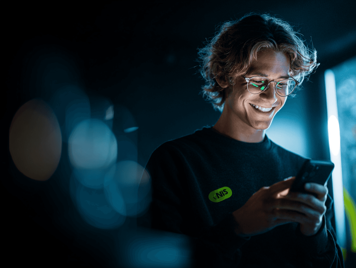 a man looking at his phone happily