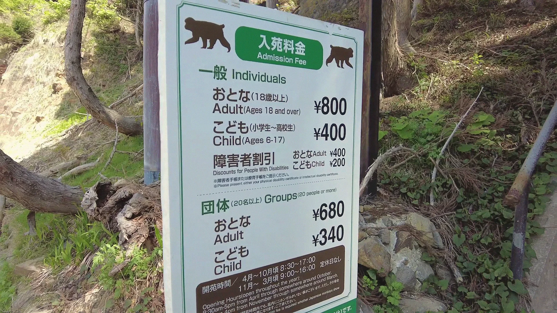 The bilingual admission-fee sign at Jigokudani Monkey Park — adults ¥800 (~US$5), children ¥400; groups ¥680/¥340 — with seasonal opening hours.