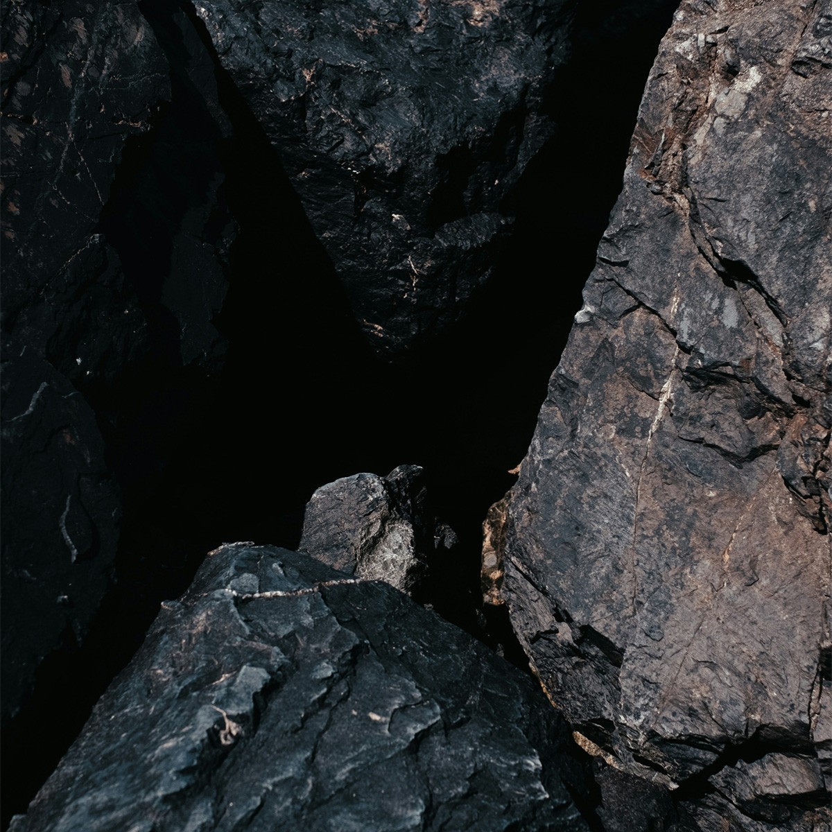 a pile of black rocks sitting next to each other