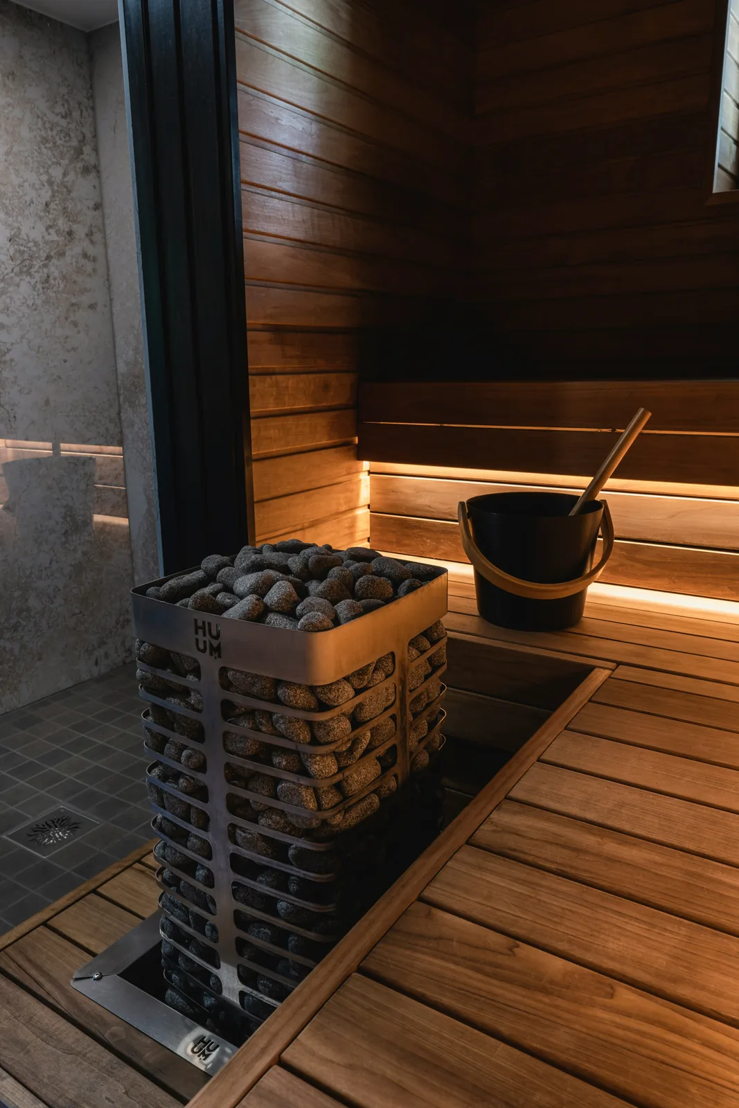 A wooden Finnish sauna with a stone heater and water bucket