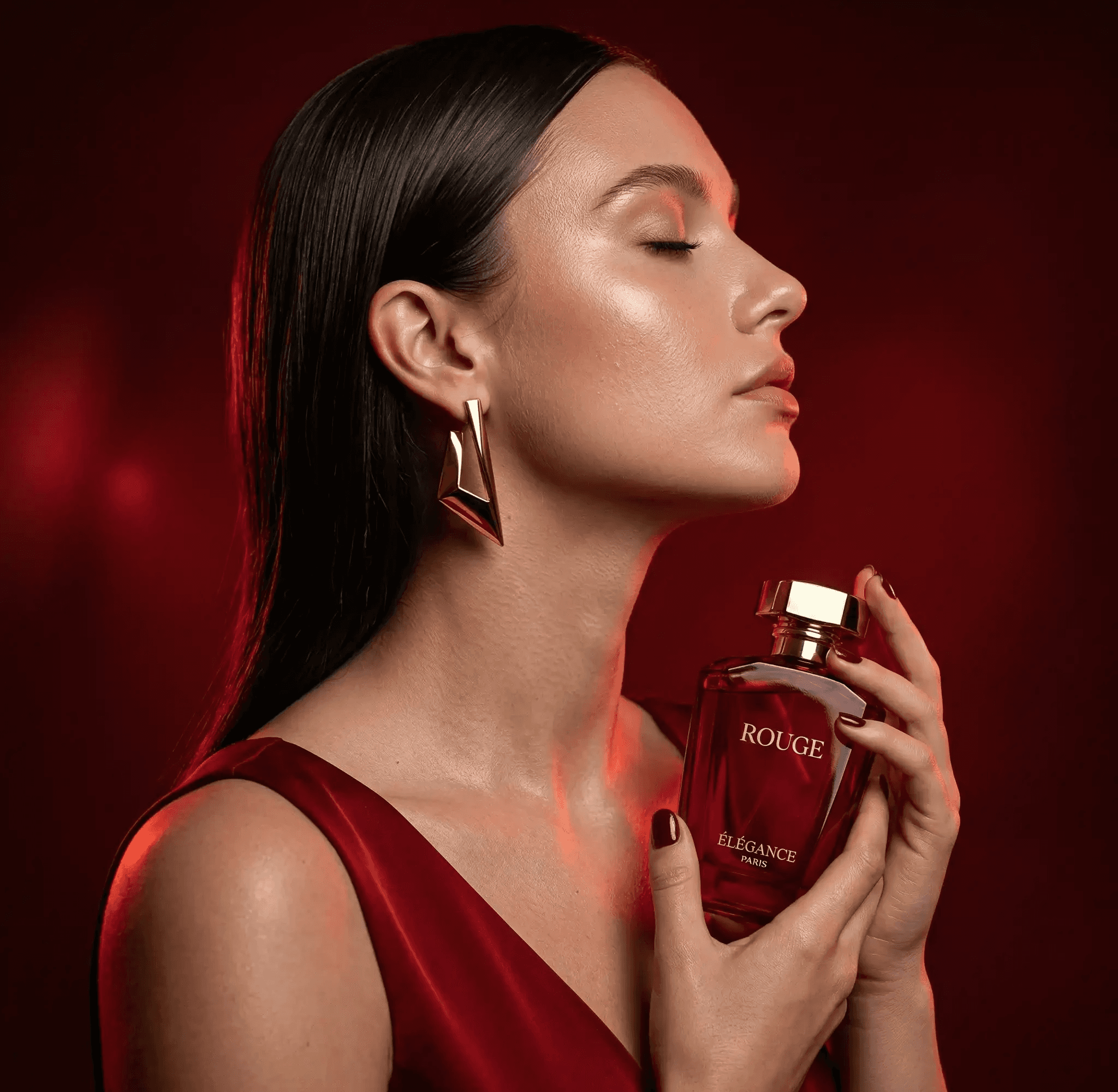 A visual marketing example showing a woman holding a bottle of Rouge Élégance Paris perfume under atmospheric red lighting. This high-end product photography is used to demonstrate luxury brand positioning by Mahindra, a specialist consultant and digital marketing trainer, who analyzes visual content strategies as a marketing trainer.