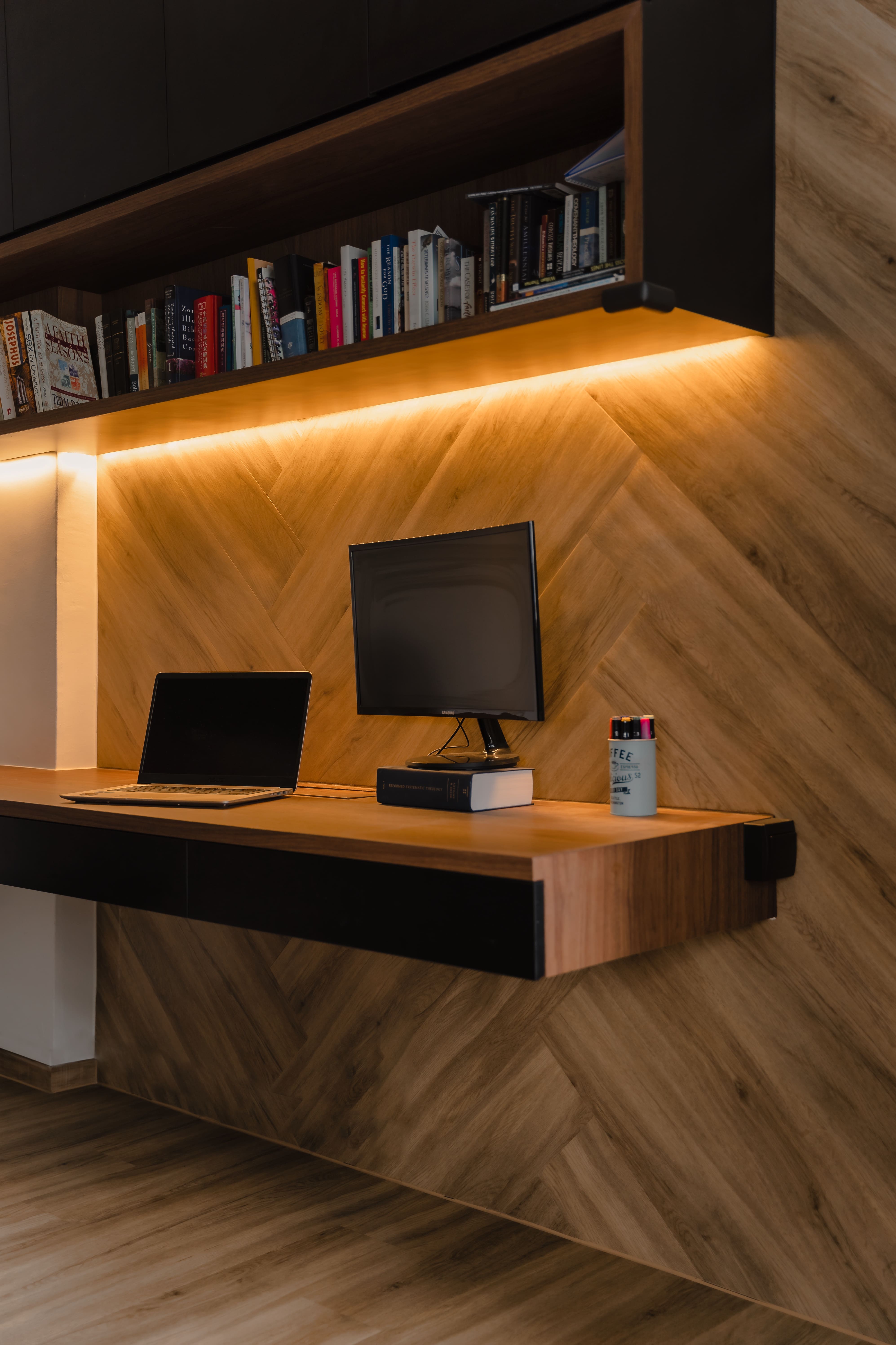 Cosy home workspace with chevron wood panelling and ambient backlighting, seamlessly blending functionality and style.