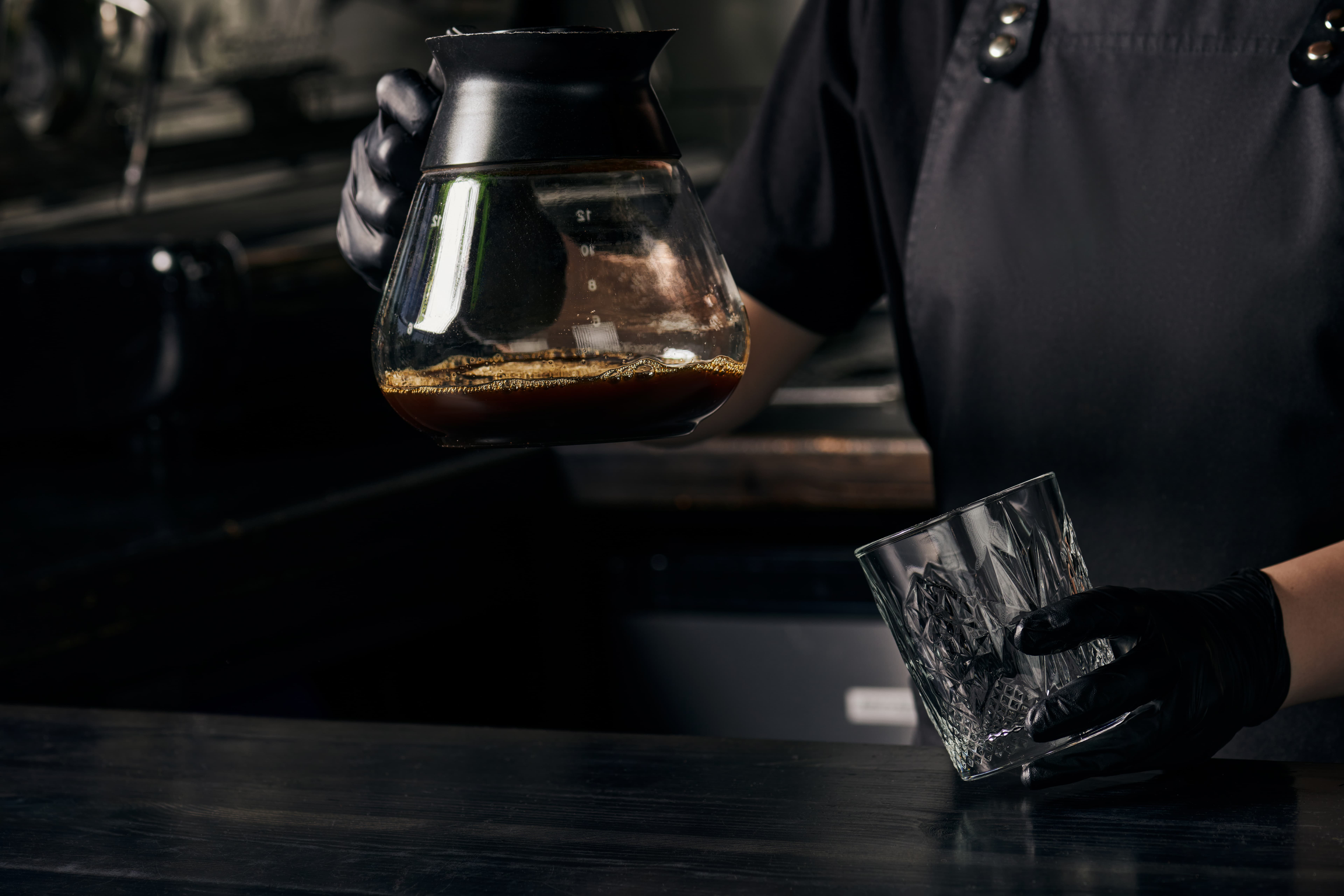 Barista tamps freshly ground coffee in a portafilter.